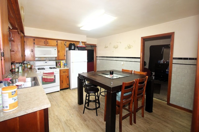 324 Illinois St, Joliet, IL 60436 - kitchen featuring white appliances, light countertops, light wood-style flooring, tile walls, and brown cabinetry