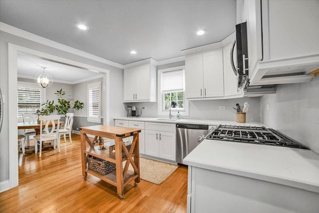 3976 Western Ave, Western Springs, IL 60558 - kitchen featuring appliances with stainless steel finishes, ornamental molding, white cabinets, light countertops, and healthy amount of natural light