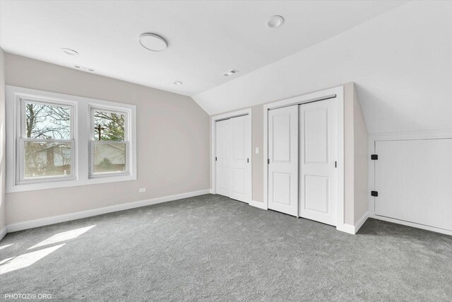 6100 W Byron St, Chicago, IL 60634 - unfurnished bedroom with multiple closets, carpet floors, and vaulted ceiling