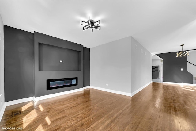 6100 W Byron St, Chicago, IL 60634 - unfurnished living room featuring a glass covered fireplace, wood finished floors, ceiling fan, and a chandelier