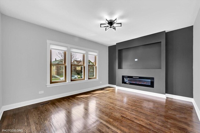 6100 W Byron St, Chicago, IL 60634 - unfurnished living room featuring a glass covered fireplace and wood finished floors