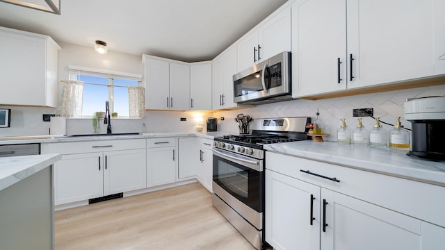 1420 Kennedy Dr, Kirkland, IL 60146 - kitchen with stainless steel appliances, light stone countertops, backsplash, and white cabinetry