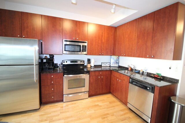 565 W Quincy St Unit 912, Chicago, IL 60661 - kitchen with appliances with stainless steel finishes, light wood finished floors, dark stone counters, and brown cabinetry