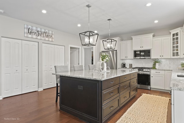 25313 W Rock Dr, Plainfield, IL 60586 - kitchen featuring stainless steel appliances, white cabinets, a breakfast bar area, backsplash, and recessed lighting
