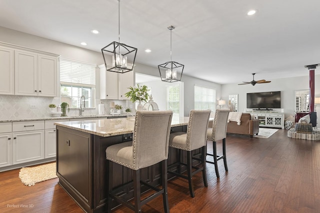 25313 W Rock Dr, Plainfield, IL 60586 - kitchen with decorative backsplash, plenty of natural light, white cabinetry, a kitchen bar, and recessed lighting