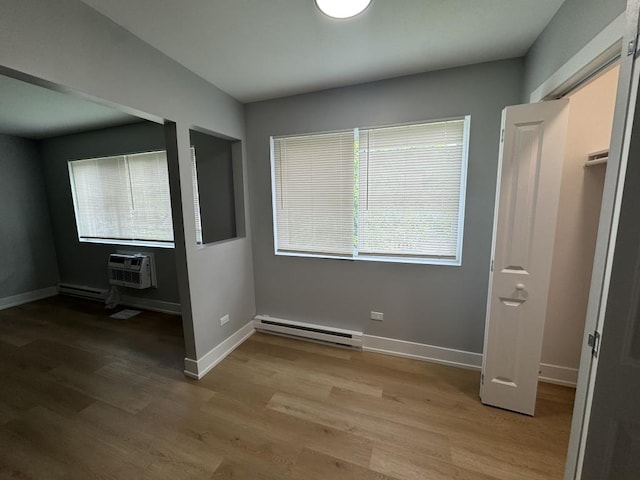 316 Marengo Ave Unit 3C, Forest Park, IL 60130 - unfurnished bedroom with a baseboard radiator, light wood-type flooring, and a wall mounted AC