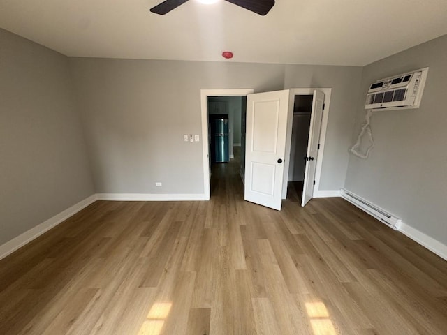 316 Marengo Ave Unit 3C, Forest Park, IL 60130 - unfurnished bedroom with a baseboard radiator, a wall mounted AC, wood finished floors, and ceiling fan
