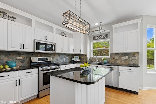527 Capital Ln, Gurnee, IL 60031 - kitchen with appliances with stainless steel finishes, white cabinetry, light wood finished floors, decorative backsplash, and a center island