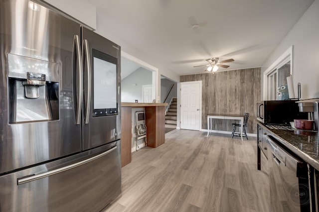 3917 Jonathan Simpson Dr, Joliet, IL 60431 - kitchen featuring appliances with stainless steel finishes, a ceiling fan, light wood-type flooring, wood walls, and dark countertops