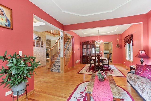2708 High Meadow Rd, Naperville, IL 60564 - living area featuring a tray ceiling, a chandelier, wood finished floors, and stairs