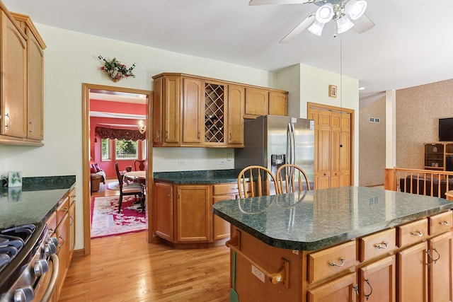 2708 High Meadow Rd, Naperville, IL 60564 - kitchen with stainless steel appliances, light wood-style flooring, ceiling fan, dark countertops, and a center island