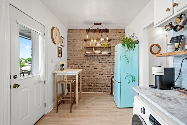 4006 W Wellington Ave Unit 3, Chicago, IL 60641 - kitchen with brick wall, freestanding refrigerator, washer / clothes dryer, light wood-style flooring, and white cabinets