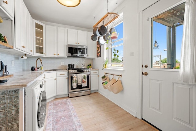 4006 W Wellington Ave Unit 3, Chicago, IL 60641 - kitchen featuring stainless steel appliances, light wood finished floors, healthy amount of natural light, and tasteful backsplash