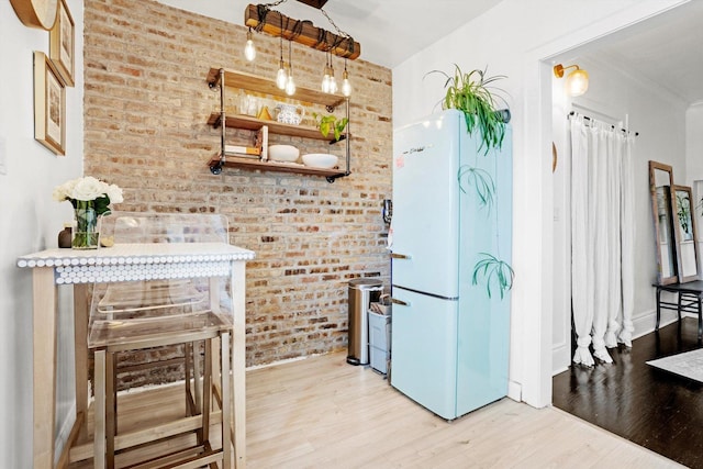 4006 W Wellington Ave Unit 3, Chicago, IL 60641 - kitchen with freestanding refrigerator, wood finished floors, and brick wall