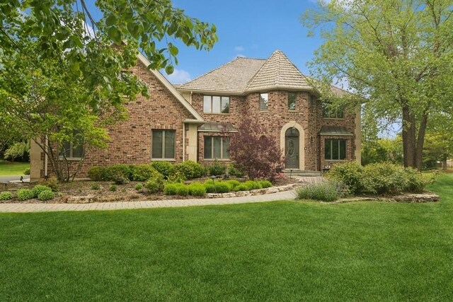 22902 W Lochanora Dr, Hawthorn Woods, IL 60047 - tudor house featuring a front yard, brick siding, and a high end roof