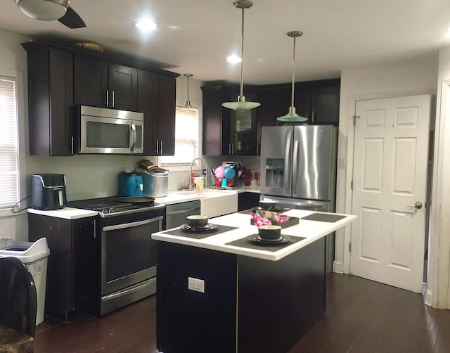 14514 Minerva Ave, Dolton, IL 60419 - kitchen featuring stainless steel appliances, light countertops, dark wood finished floors, a center island, and pendant lighting