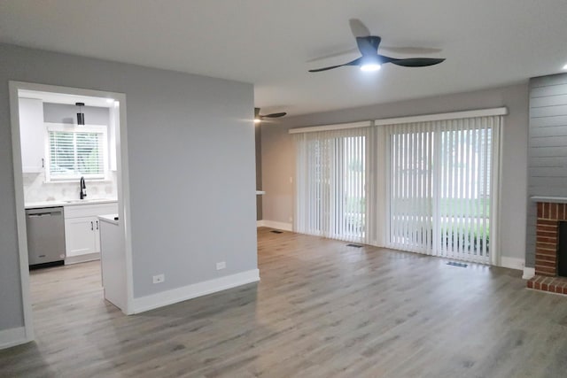 369 Ferndale Ct Unit B1, Schaumburg, IL 60193 - unfurnished living room with a ceiling fan, light wood-style floors, and a brick fireplace