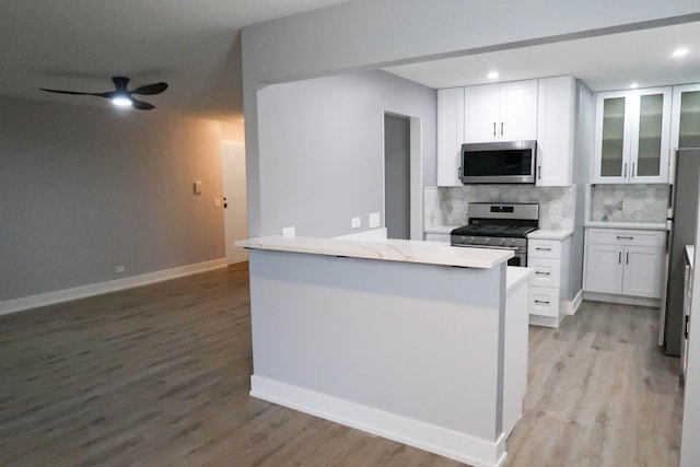 369 Ferndale Ct Unit B1, Schaumburg, IL 60193 - kitchen with appliances with stainless steel finishes, tasteful backsplash, white cabinets, light wood-type flooring, and ceiling fan