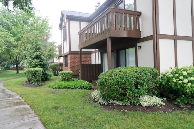 369 Ferndale Ct Unit B1, Schaumburg, IL 60193 - view of property exterior with stucco siding, a balcony, a lawn, and brick siding