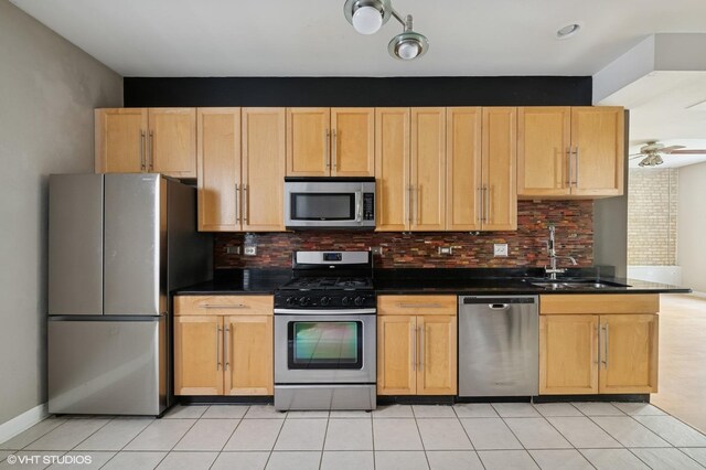4510 N Ashland Ave Unit Gw, Chicago, IL 60640 - kitchen featuring appliances with stainless steel finishes, dark countertops, tasteful backsplash, and light tile patterned floors