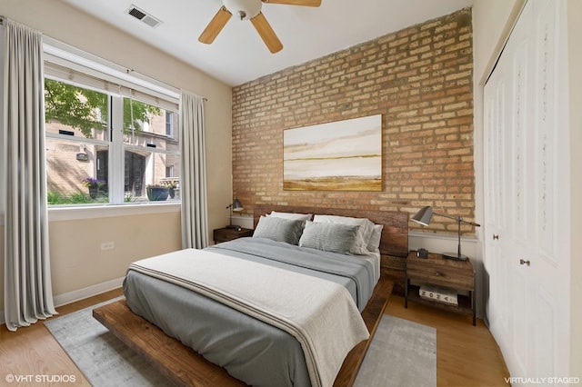 4510 N Ashland Ave Unit Gw, Chicago, IL 60640 - bedroom featuring a closet, brick wall, wood finished floors, and ceiling fan