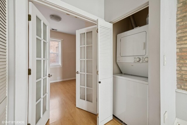 4510 N Ashland Ave Unit Gw, Chicago, IL 60640 - laundry area with stacked washer and clothes dryer, french doors, and light wood-style floors