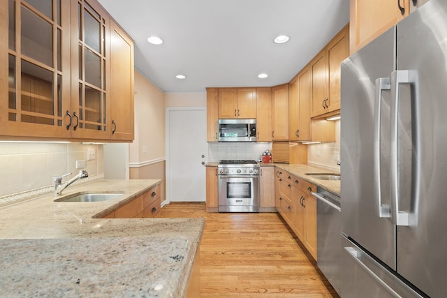 500 W Evergreen St, Wheaton, IL 60187 - kitchen with appliances with stainless steel finishes, decorative backsplash, light stone counters, light wood-style floors, and recessed lighting