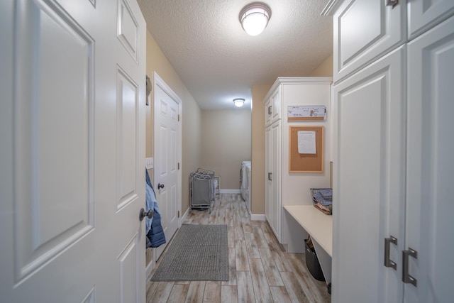 4526 Winn Rd, Sterling, IL 61081 - mudroom featuring washing machine and clothes dryer, light wood-style flooring, and a textured ceiling