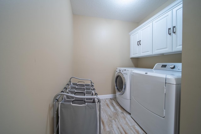 4526 Winn Rd, Sterling, IL 61081 - laundry area featuring independent washer and dryer, cabinet space, light wood-type flooring, and a textured ceiling