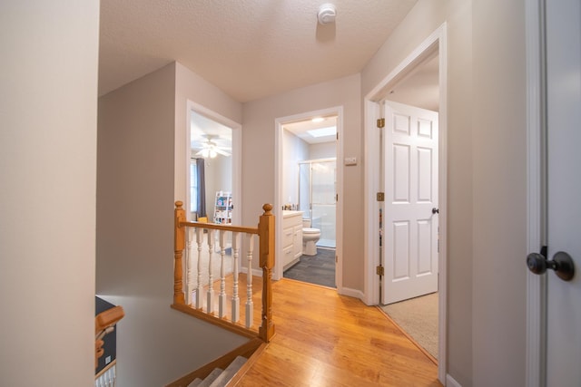 4526 Winn Rd, Sterling, IL 61081 - corridor with an upstairs landing, light wood-type flooring, and a textured ceiling