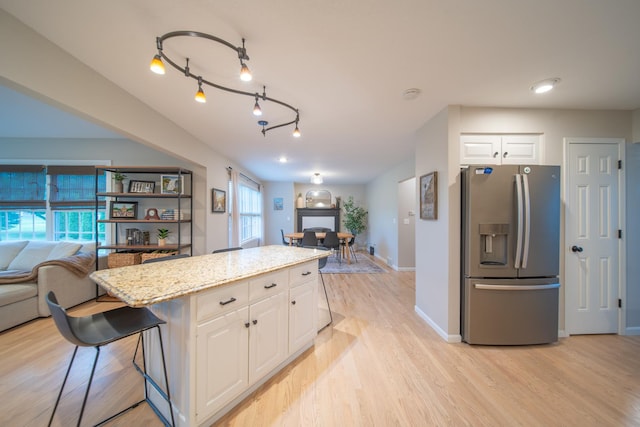 4526 Winn Rd, Sterling, IL 61081 - kitchen featuring stainless steel refrigerator with ice dispenser, light wood-style floors, white cabinetry, open floor plan, and light stone counters
