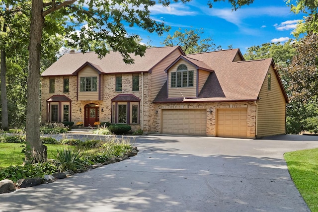 195 Hollow Way, Ingleside, IL 60041 - view of front of home with concrete driveway, brick siding, a shingled roof, and an attached garage