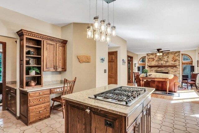 195 Hollow Way, Ingleside, IL 60041 - kitchen with stainless steel gas cooktop, open shelves, a large fireplace, a ceiling fan, and open floor plan