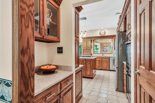 195 Hollow Way, Ingleside, IL 60041 - kitchen featuring brown cabinetry, glass insert cabinets, light stone counters, and appliances with stainless steel finishes
