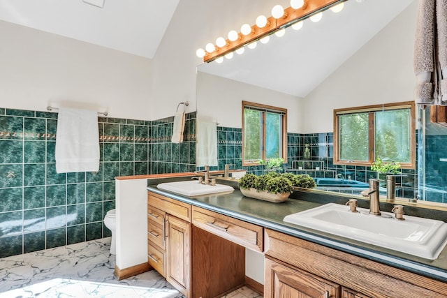 195 Hollow Way, Ingleside, IL 60041 - bathroom featuring tile walls, double vanity, a bath, marble finish floors, and high vaulted ceiling