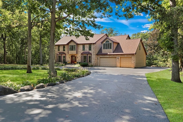 195 Hollow Way, Ingleside, IL 60041 - view of front facade with concrete driveway, a front lawn, brick siding, and an attached garage