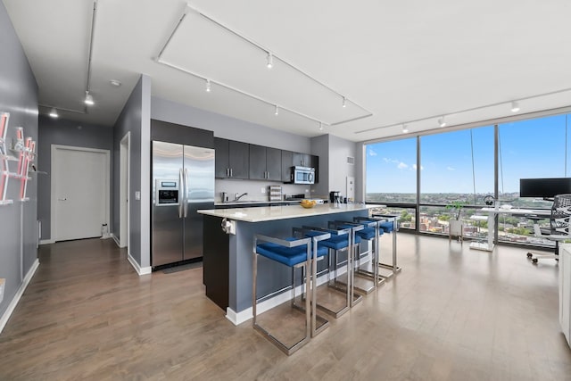860 W Blackhawk St Unit 2106, Chicago, IL 60642 - kitchen with appliances with stainless steel finishes, rail lighting, light countertops, a kitchen island, and a kitchen bar