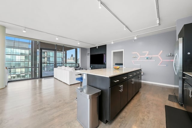 860 W Blackhawk St Unit 2106, Chicago, IL 60642 - kitchen featuring rail lighting, a center island, light wood-style flooring, open floor plan, and dark cabinetry