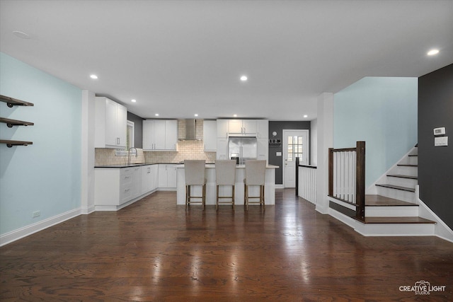 515 W Diversey Ave, Addison, IL 60101 - kitchen featuring stainless steel fridge with ice dispenser, wall chimney exhaust hood, backsplash, a kitchen island, and white cabinetry