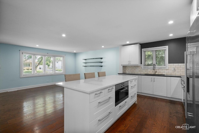 515 W Diversey Ave, Addison, IL 60101 - kitchen featuring tasteful backsplash, dark wood-style flooring, recessed lighting, white cabinetry, and appliances with stainless steel finishes
