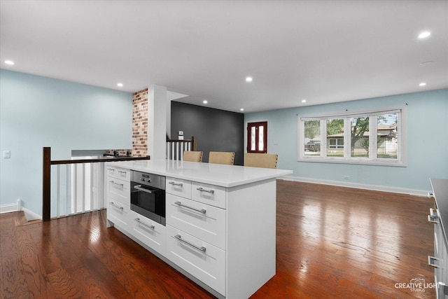 515 W Diversey Ave, Addison, IL 60101 - kitchen with dark wood-type flooring, white cabinets, a kitchen island, recessed lighting, and light countertops