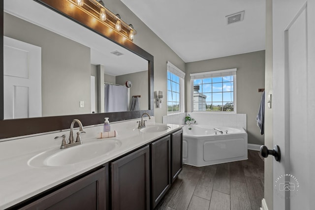 2027 Heatherstone Ct, Plainfield, IL 60586 - bathroom featuring double vanity, a bath, and wood finished floors
