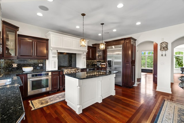11010 W 131st St, Palos Park, IL 60464 - kitchen with stainless steel appliances, arched walkways, dark wood-style floors, glass insert cabinets, and decorative backsplash