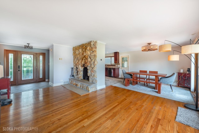 21W724 Park Ave, Lombard, IL 60148 - living room with light wood-style flooring, ornamental molding, and a stone fireplace