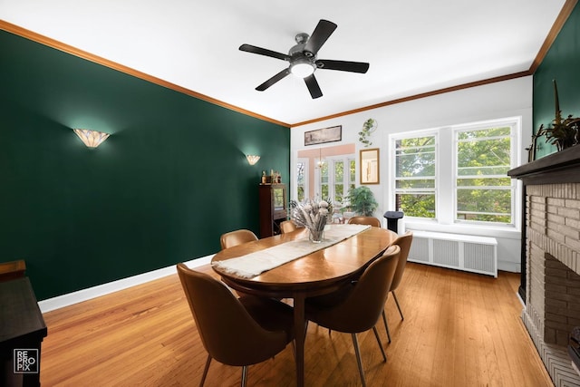 1252 W Pratt Blvd Unit 2, Chicago, IL 60626 - dining room with radiator, a fireplace, hardwood / wood-style floors, crown molding, and a ceiling fan