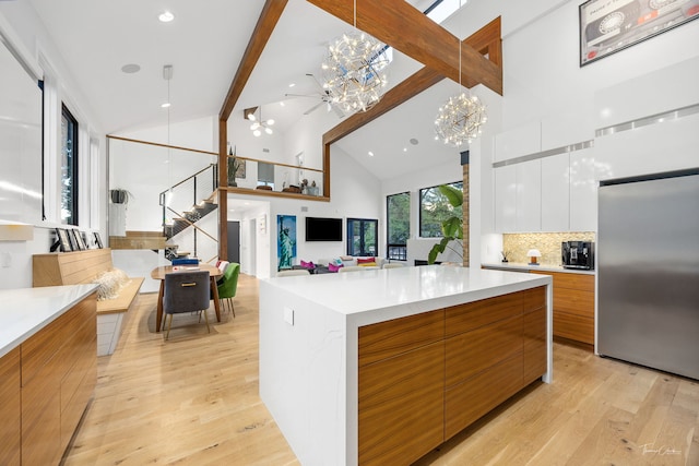 5401 Carpenter St, Downers Grove, IL 60515 - kitchen featuring modern cabinets, stainless steel fridge, a chandelier, light wood finished floors, and high vaulted ceiling