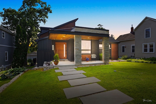 5401 Carpenter St, Downers Grove, IL 60515 - contemporary home featuring a yard, stone siding, board and batten siding, and a porch