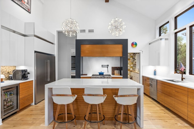5401 Carpenter St, Downers Grove, IL 60515 - kitchen with stainless steel appliances, modern cabinets, high vaulted ceiling, beverage cooler, and a chandelier