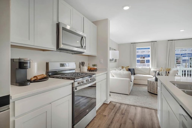 442 Lakeshore Ct, Saint Charles, IL 60174 - kitchen with stainless steel appliances, light wood-style floors, open floor plan, white cabinetry, and light countertops