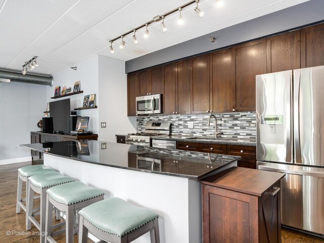 1100 W Montrose Ave Unit 207, Chicago, IL 60613 - kitchen with stainless steel appliances, a center island, rail lighting, and backsplash